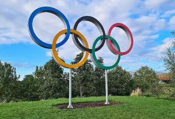 An outdoors sculpture of five coloured rings 