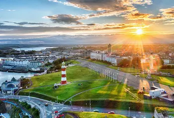 Aerial view of Plymouth coast with lighthouse and dramatic sunrise