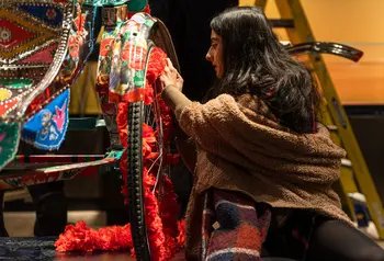 Person painting a rickshaw on display in the South Asia Gallery at Manchester Museum