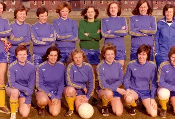 Women's football team face the camera in two rows - one standing behind, one kneeling in front.