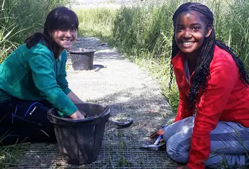 Two women working on a path at a wildlife reserve