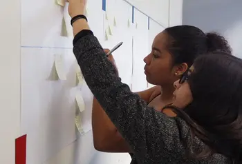 Two young people observing a notice board