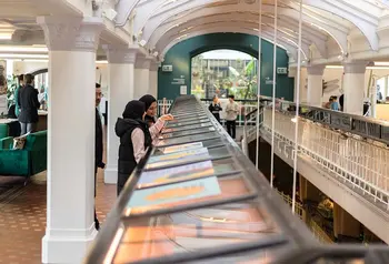 People looking at display cases in a mezzanine gallery.