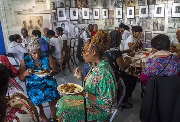 Groups of older people sitting eating at tables at the Migration Museum