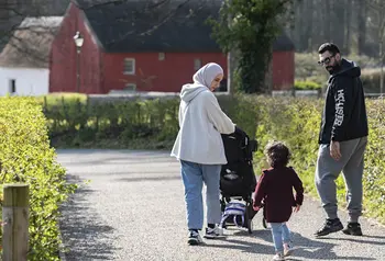 A family of two adults and a young child in the grounds of St Fagans Museum