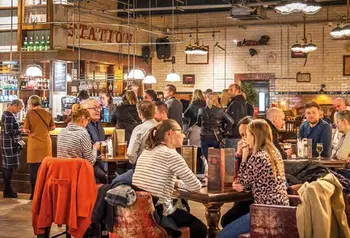 A well lit, crowded bar with people sitting at tables