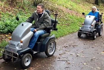 People driving mobility scooters through a park