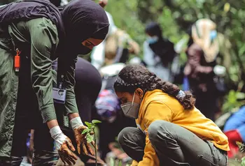 Two women planting trees