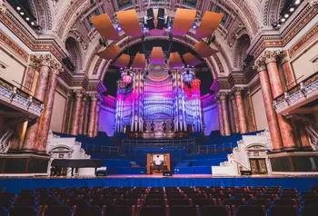 The interior of Leeds Town Hall with someone playing the organ on stage.