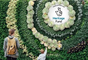 The National Lottery Heritage Fund acknowledgement stamp is displayed in the centre of a living plant wall