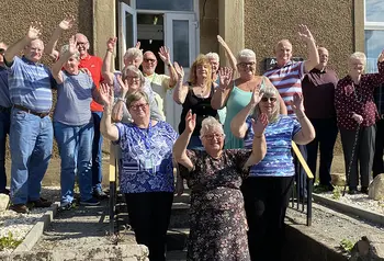 A group of older people waving