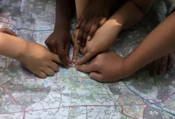 Photograph of hands pointing at a map