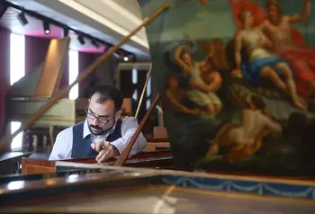 Conservator Jonathan Santa Maria Bouquet tuning a harpsichord in the museum 