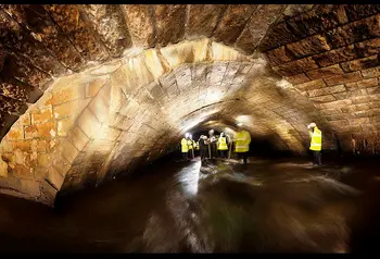 People inspecting the River Roch's medieval bridge