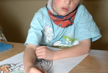 A young boy drawing at Dove Cottage 