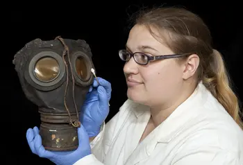 Conservation intern Louise Stewart cleaning a gas mask for the exhibition