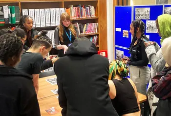 A group of people working around a table looking at research materials