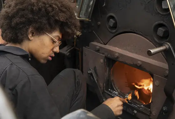 Young person working on a steam train at Blaunau Ffestiniog railway. Credit: Colin McClean