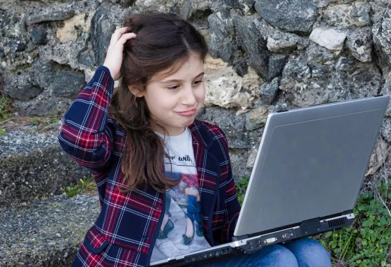 Young person looking at phone on beach