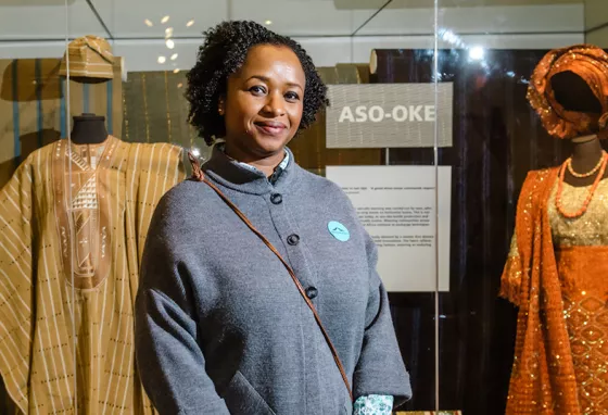 A curator in front of display of African costume