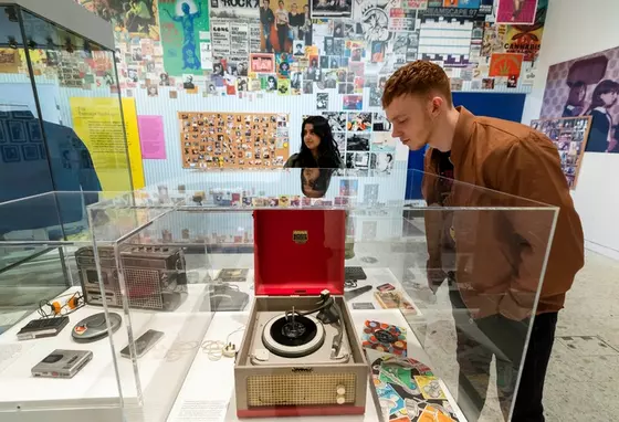 Museum of Youth image showing a person looking at a record player in a display