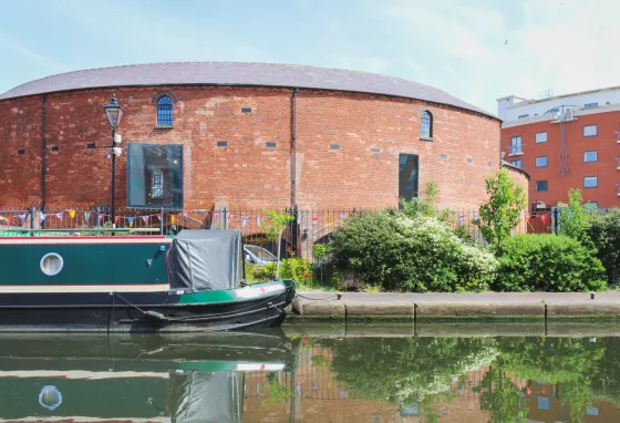 Round building with canal in foreground