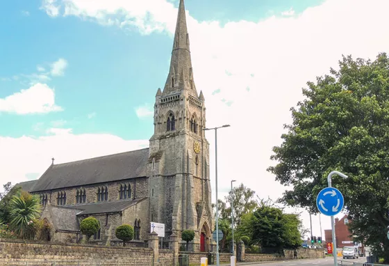 A stone church with a spire, in a town