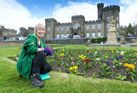 Woman crouching in grounds of a castle