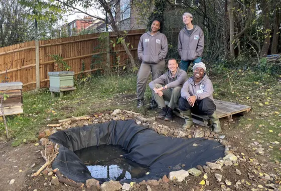 Four members of the Froglife team stand around a newly built pond