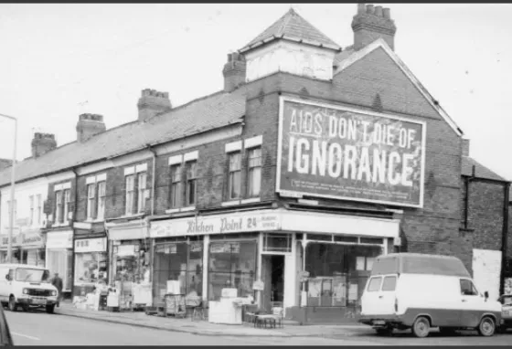 Old photo showing large billboard with the words "AIDS: don't die of ignorance"