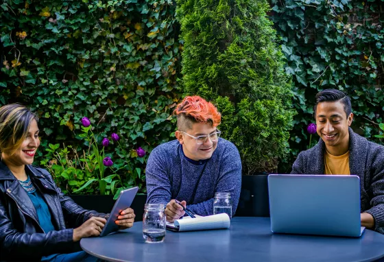 Three people using laptop and tablet