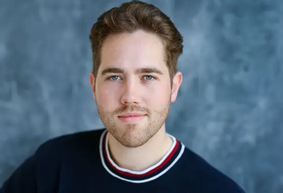 A studio portrait of a man with short brown hair