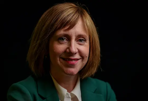 Head and shoulder portrait of Roisha Hughes with dark background