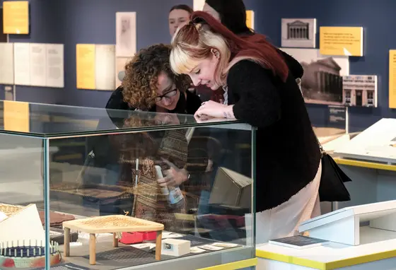 Two women looking into a glass museum display case.