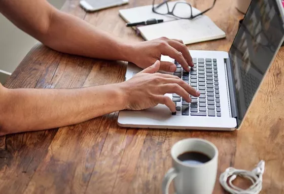 Man typing on laptop on desk