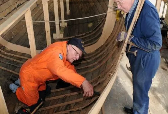 Apprentices learning traditional boat building skills