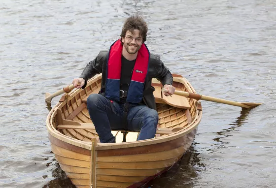 A man in a dinghy on the River Clyde