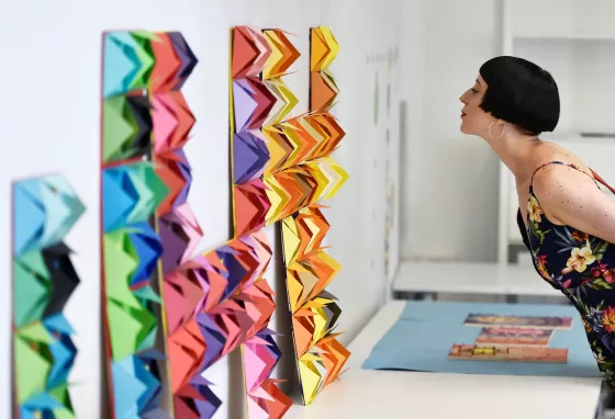 A woman looks at a colourful exhibit 