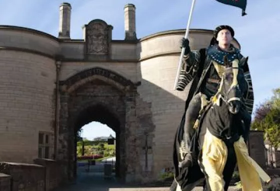 A horseman in costume rides out of Nottingham Castle