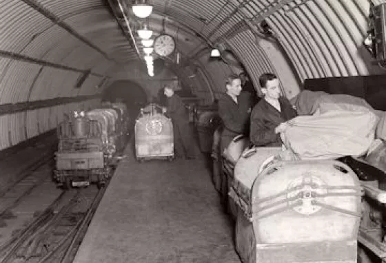 People sort post on the subterranean Mail Rail train