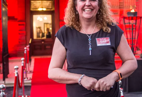 Karen Perkins stands at a red carpet event, smiling broadly