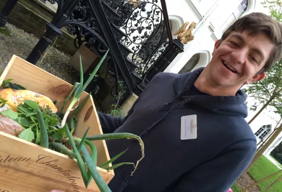 Jack, volunteer at Strawberry Hill, carrying vegetable grown in the garden