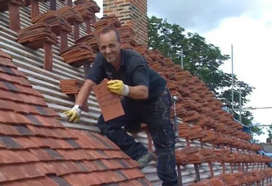 A man retiling the roof at Finchingfield