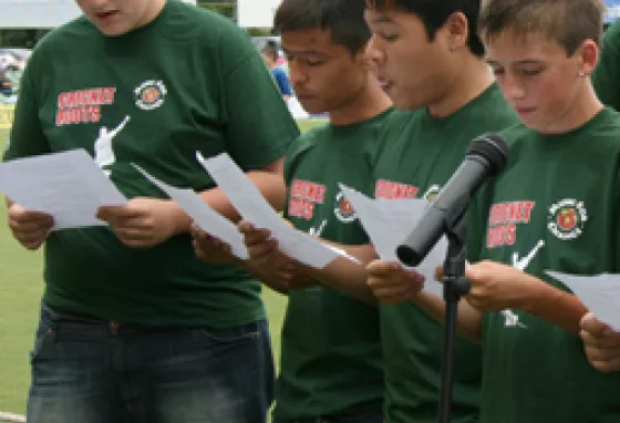 Young people performing a song at a cricket match