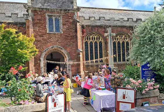 a market outside a historic brick church in summer