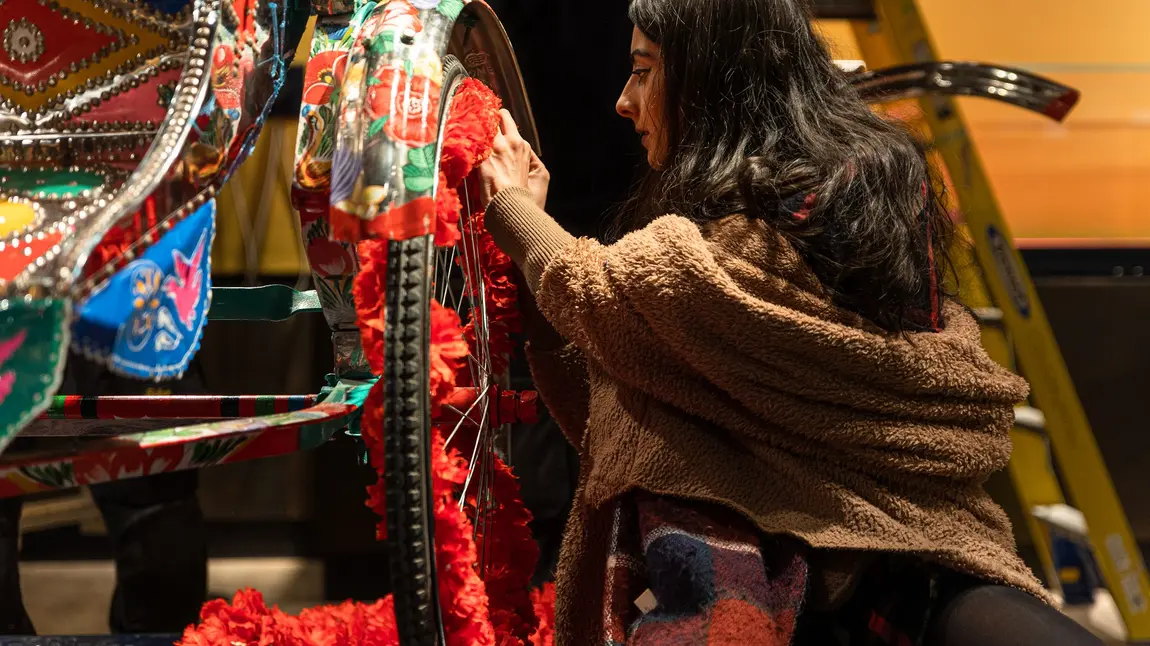 Person painting a rickshaw on display in the South Asia Gallery at Manchester Museum