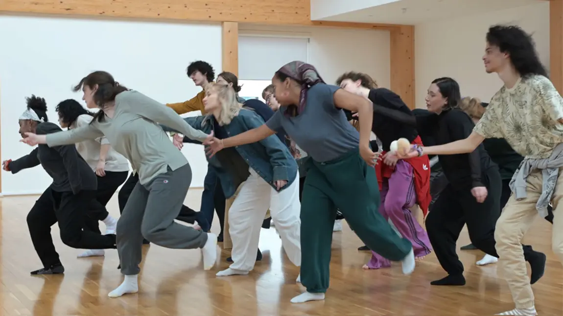 A group of people are in a studio taking part in a movement and dance workshop