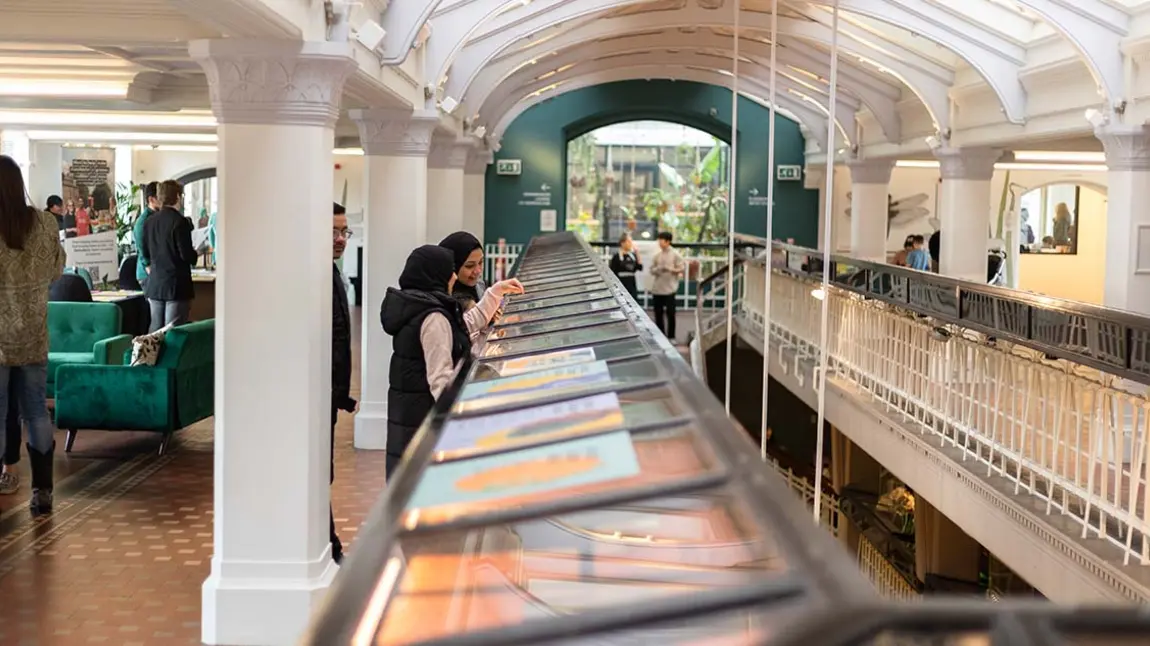 People looking at display cases in a mezzanine gallery.