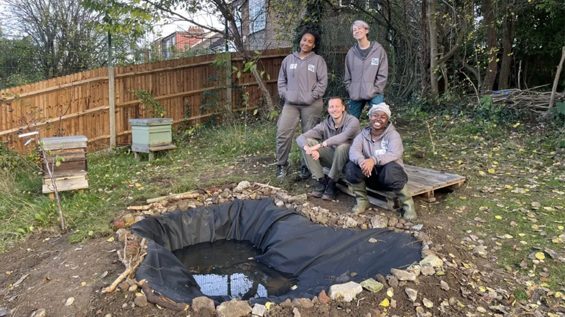 Four members of the Froglife team stand around a newly built pond