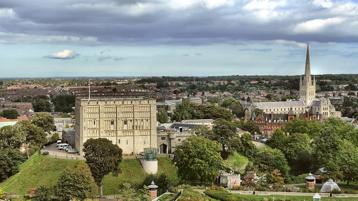 exterior view of a large norman castle in the middle of a city